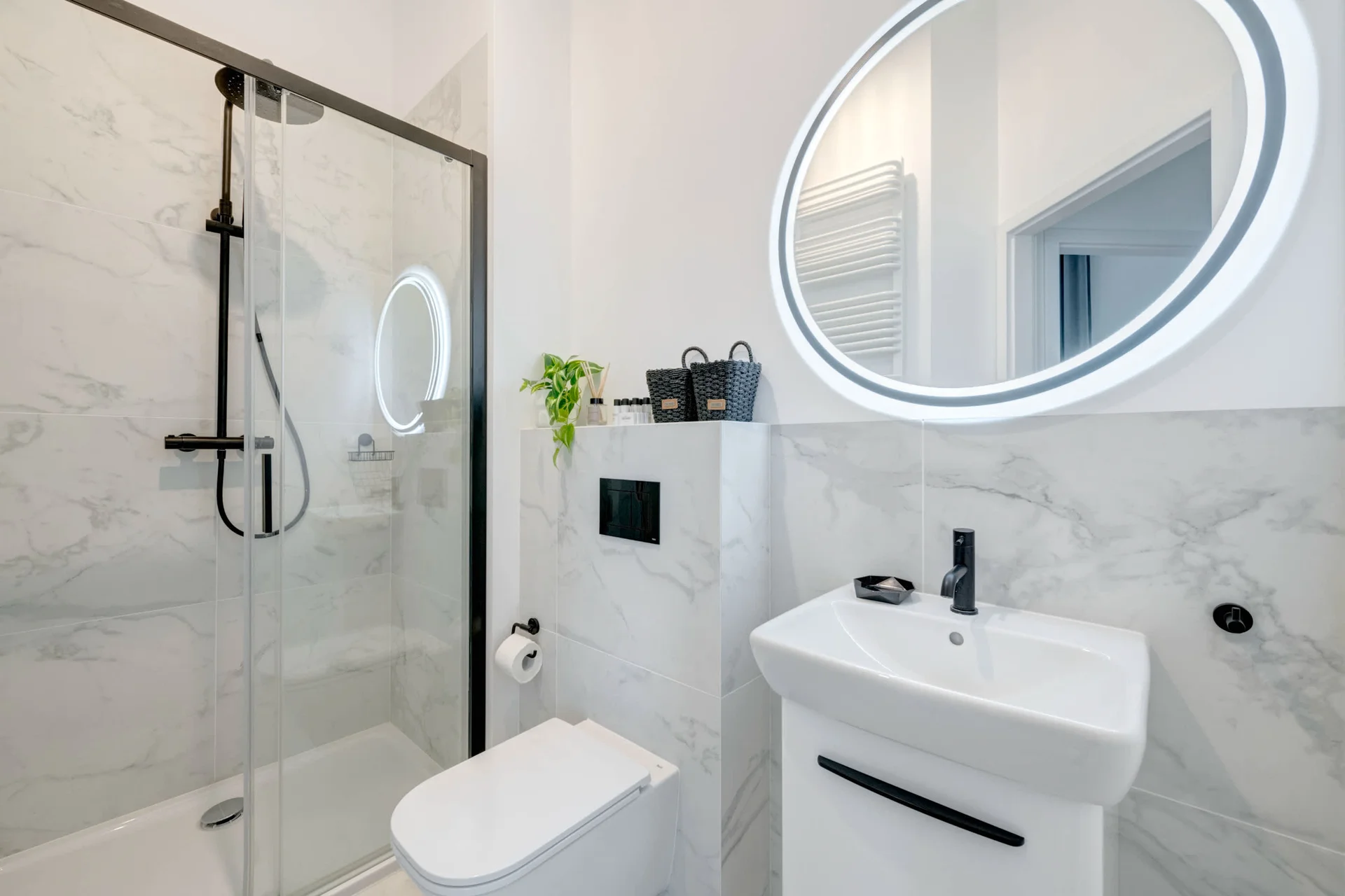 A sleek bathroom with a walk-in shower, white fixtures, and light-colored tiles for a clean and contemporary look.