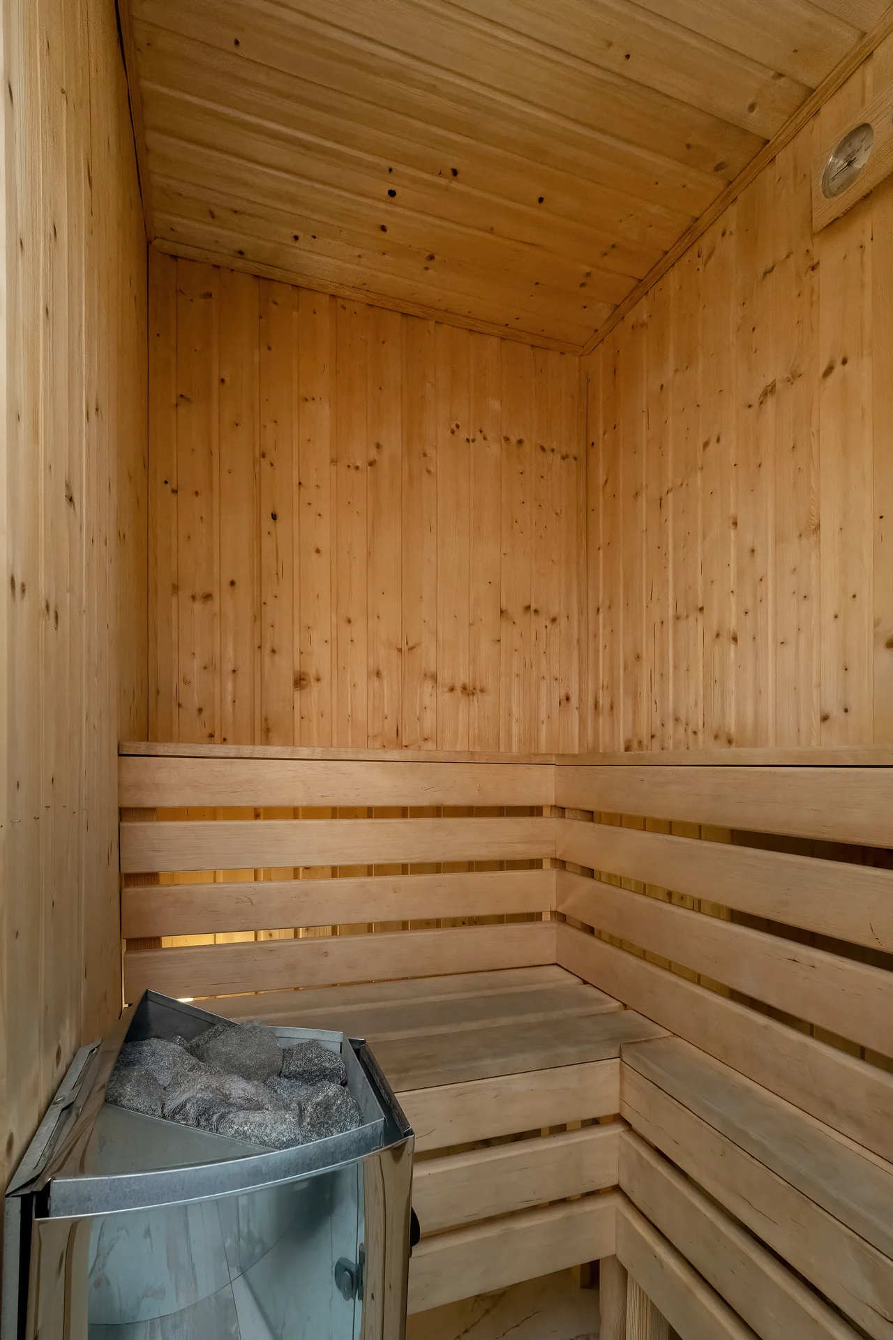 Wooden sauna with natural timber walls and built-in wooden benches.