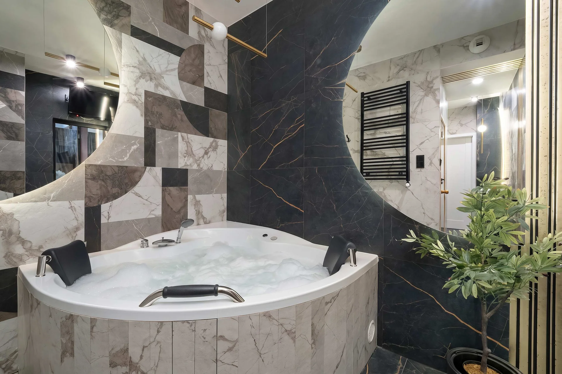 Luxurious bathroom with a freestanding bathtub, marble-effect tiles, and modern fixtures.