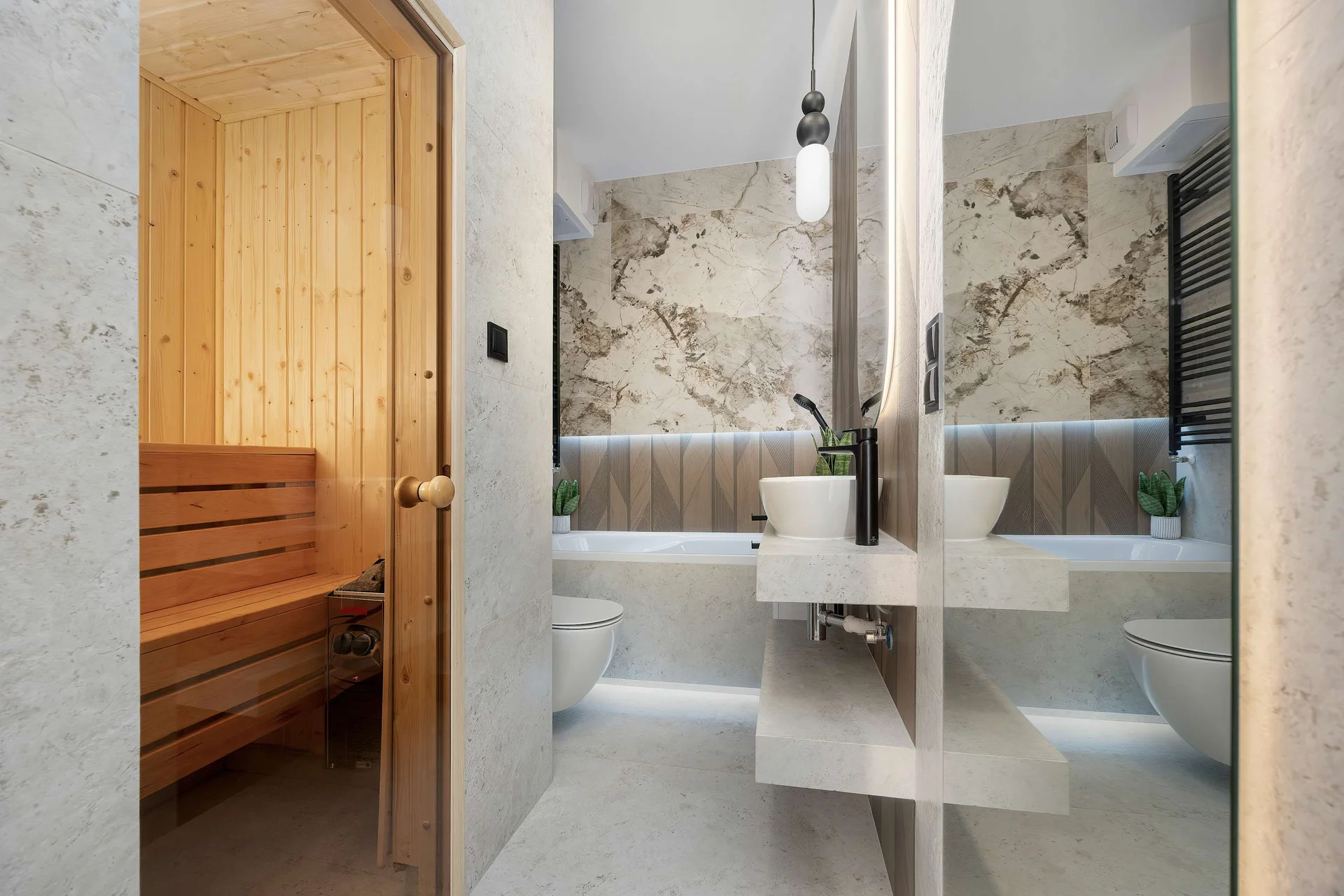 A contemporary bathroom featuring a glass-enclosed shower, a stylish washbasin, and elegant marble-effect wall tiles. A private wooden sauna adds an extra touch of comfort and relaxation.