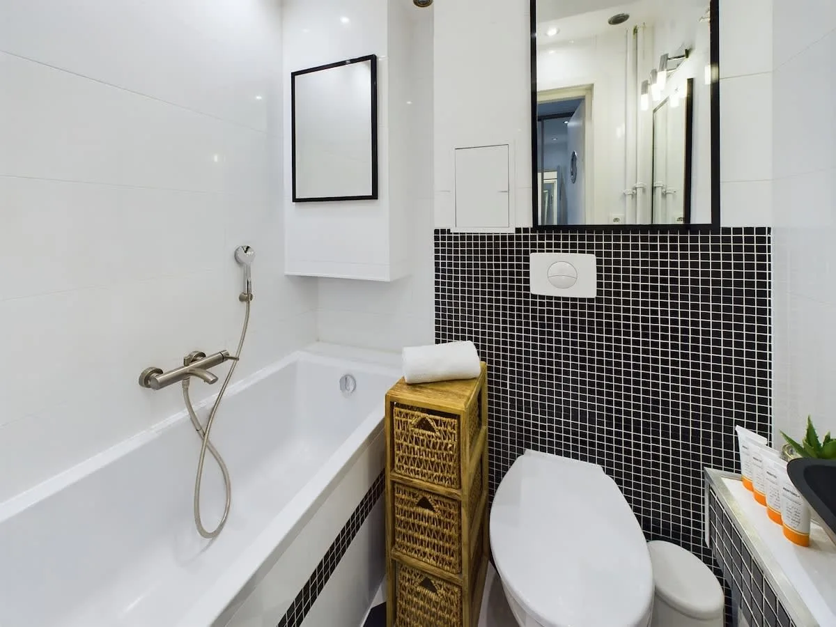 Bathroom with a bathub, toilet, sink and mirror.