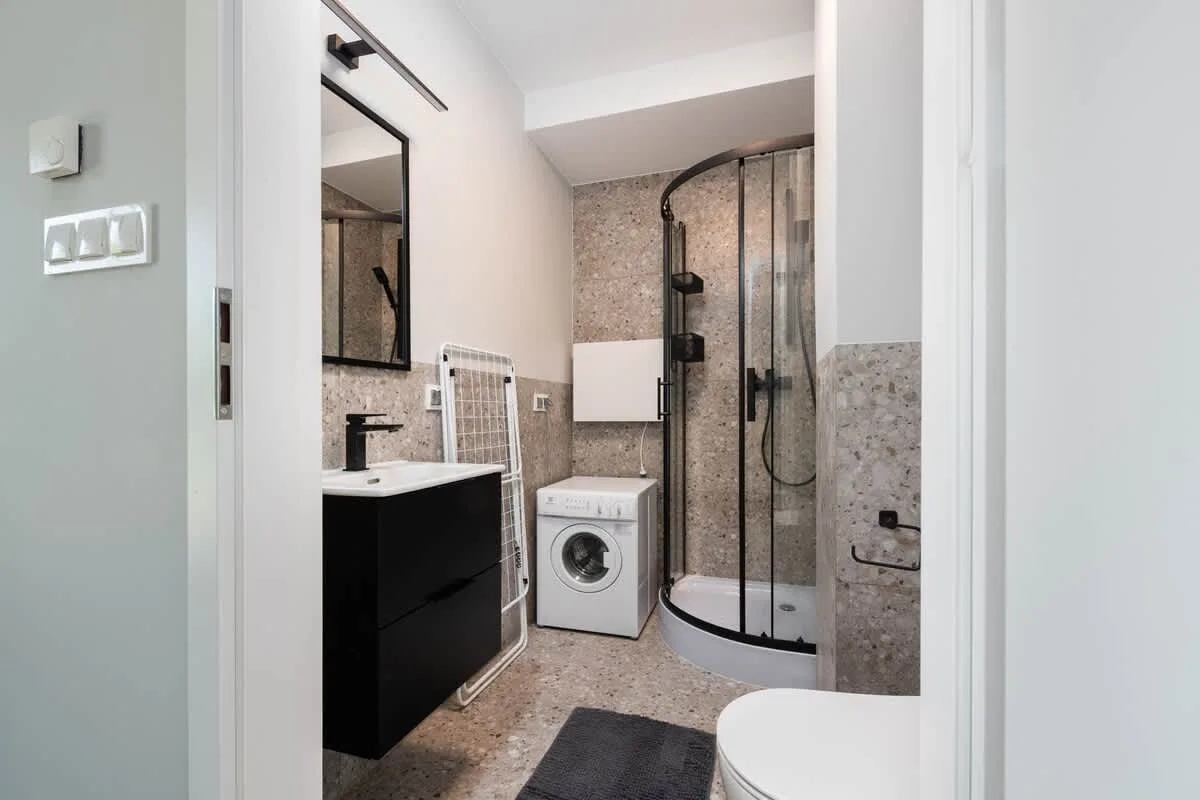 The bathroom's contemporary design includes fresh towels and a hairdryer.