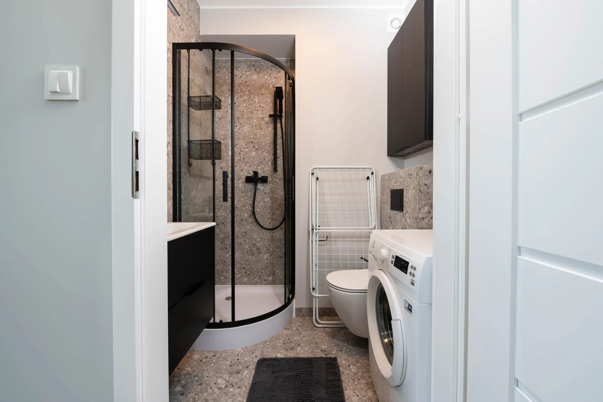 Modern bathroom with shower and washing machine.