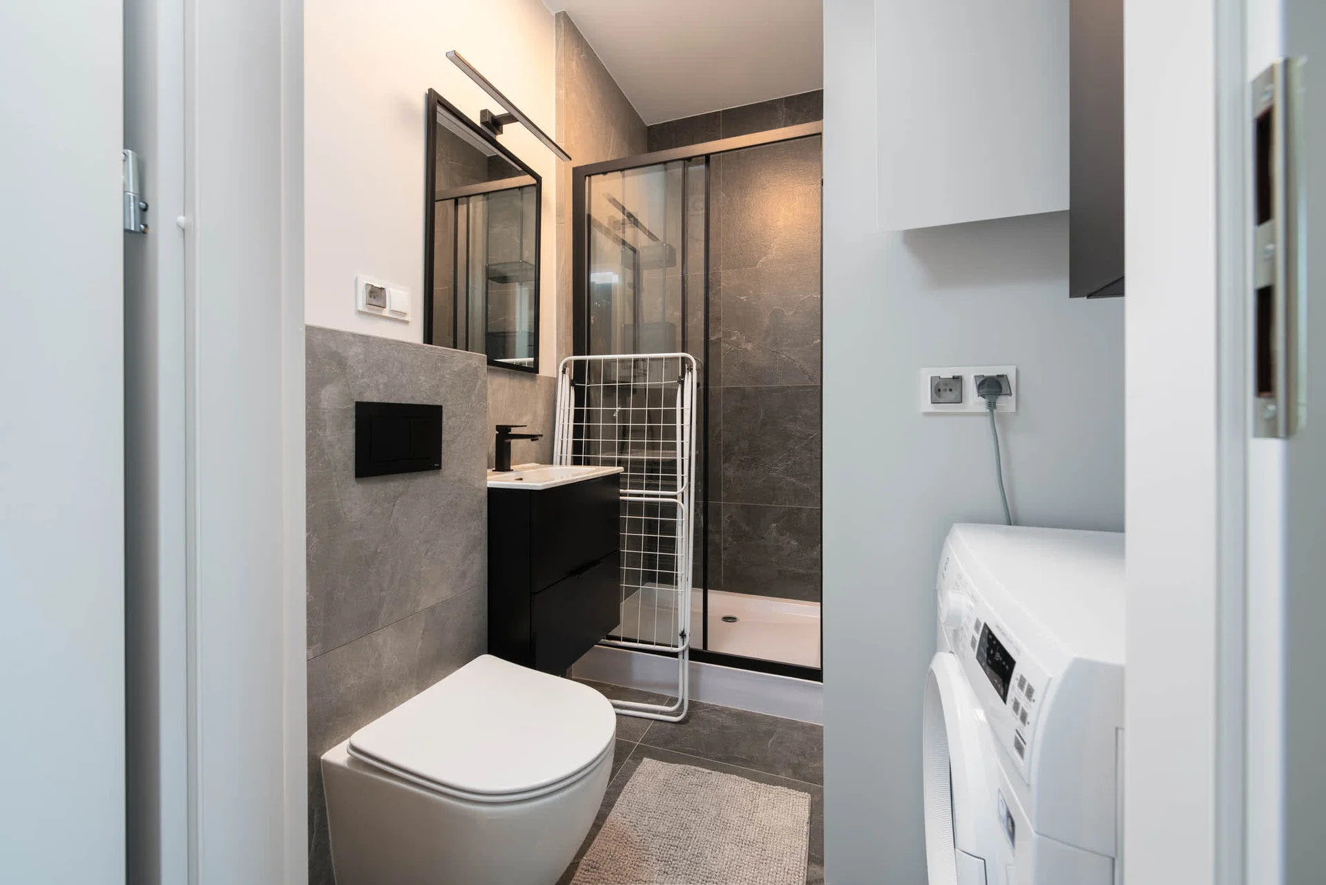 The bathroom's contemporary design includes fresh towels and a hairdryer.