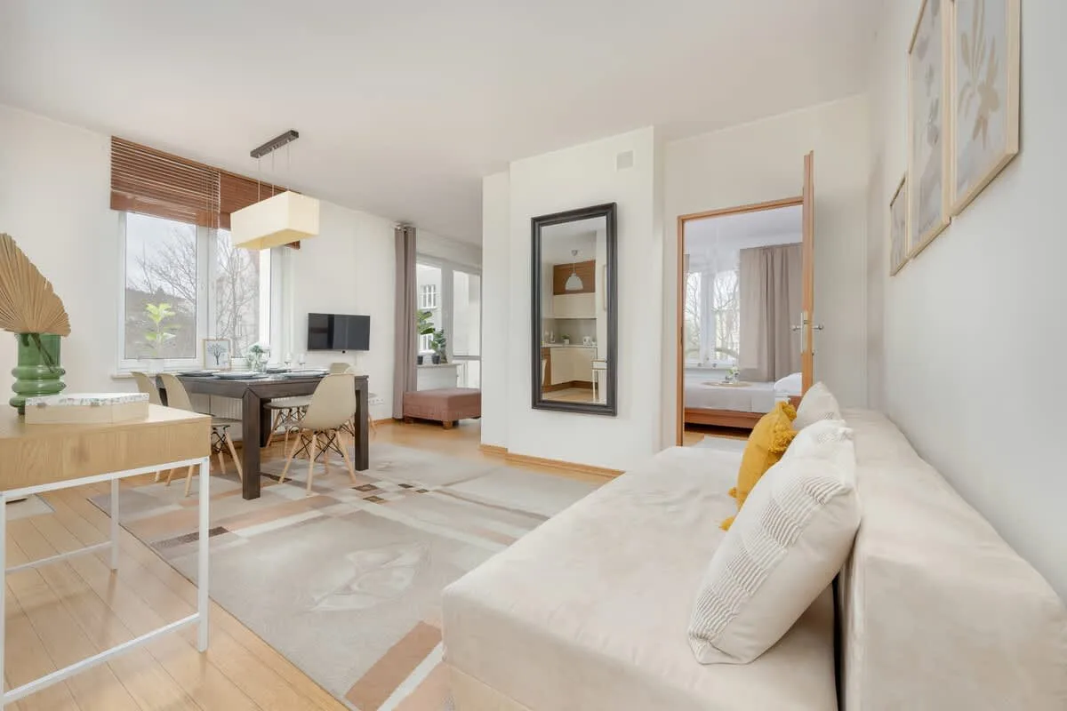 A spacious and elegantly designed living room with a comfortable sofa, a wooden coffee table, and stylish decor, creating a cozy atmosphere.