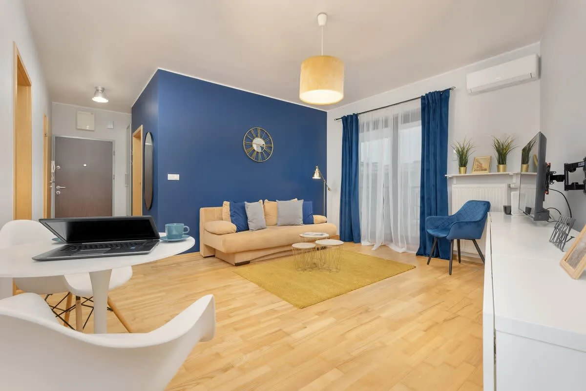 A spacious open-plan living and dining area with blue and yellow color scheme, creating a lively and welcoming environment.