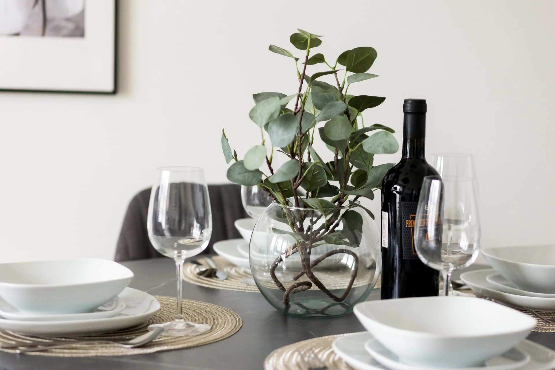 A close-up of a dining table set elegantly with plates, glasses, and a centerpiece.