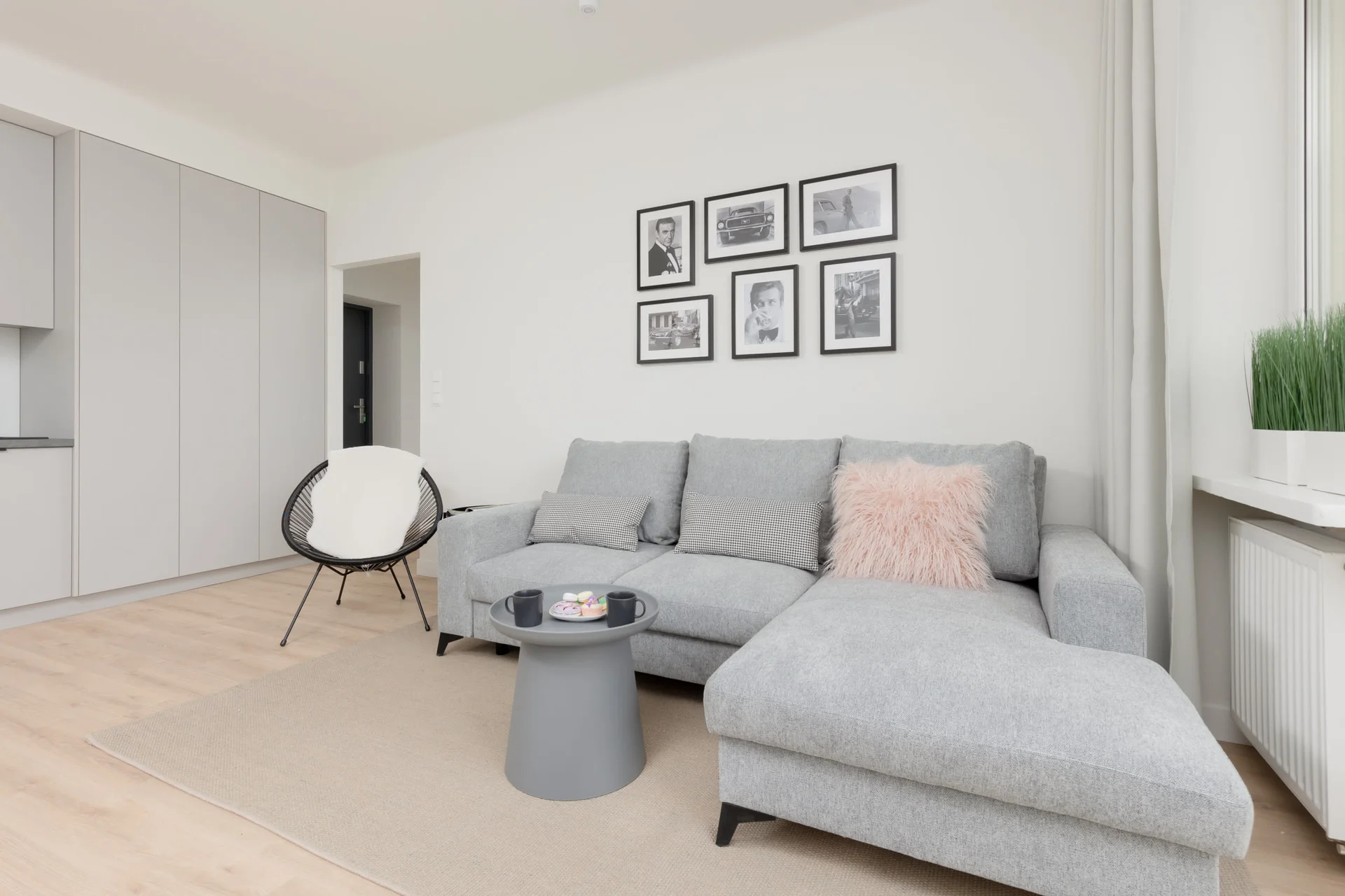 A cozy living room with a light gray sofa, modern decor, and soft lighting.