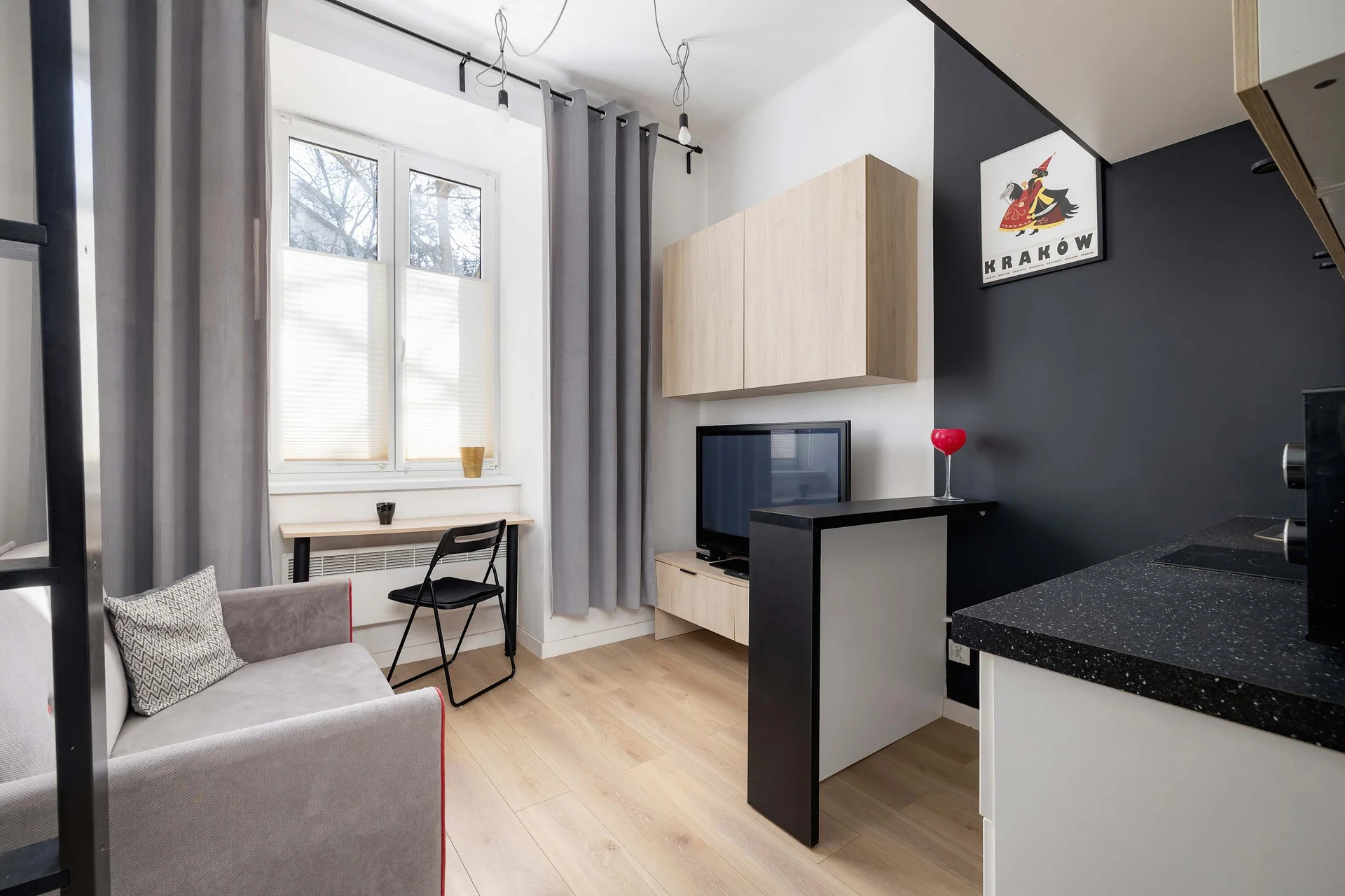 A view of a compact studio with a mezzanine floor, large windows and bright decor for coziness and functionality.