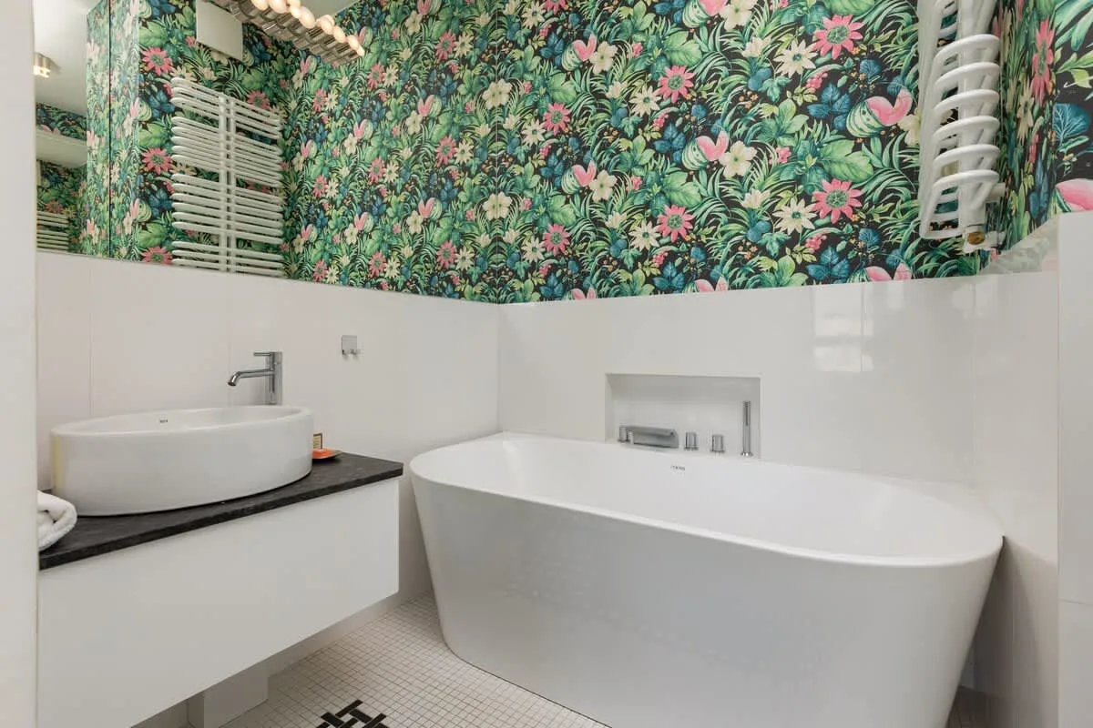 Bathroom with a bathtub, toilet, washbasin, mirror and hairdryer.