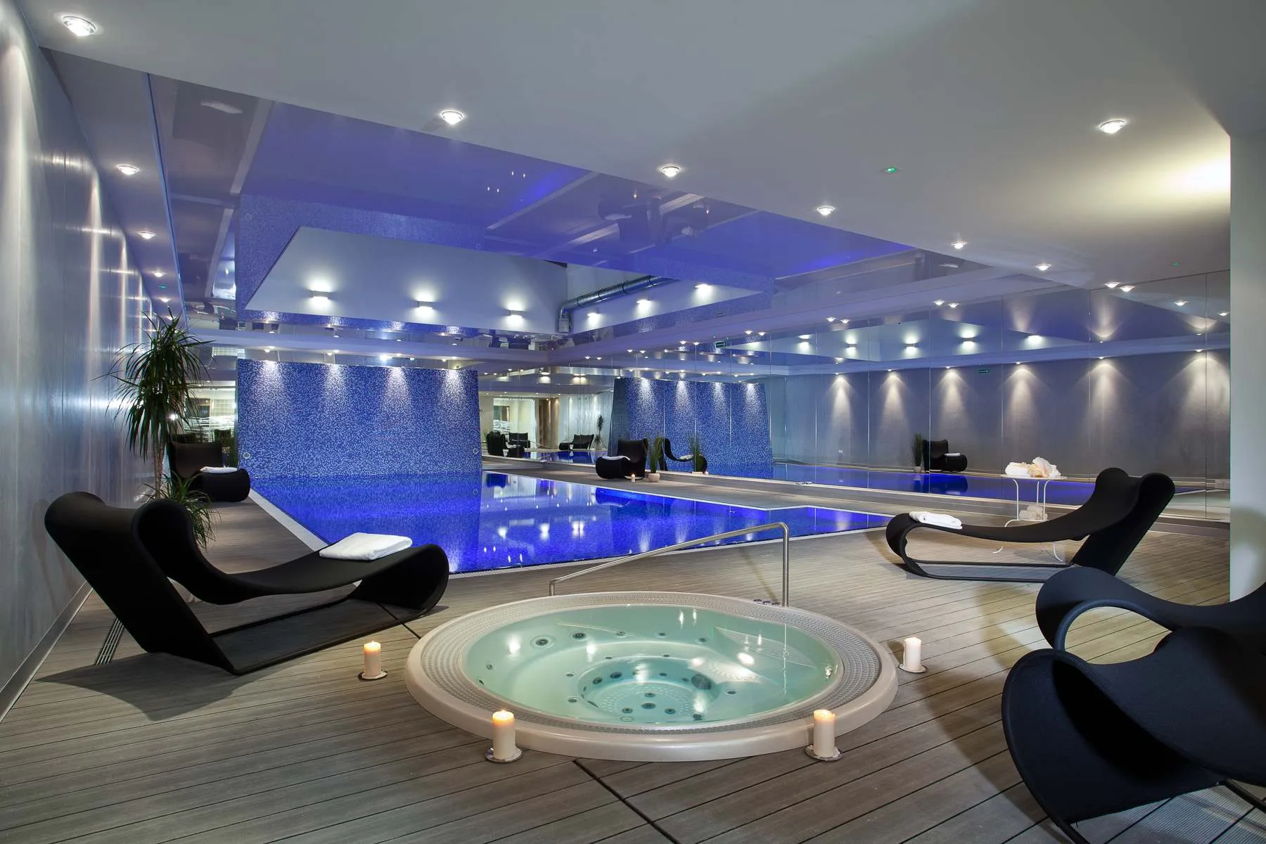 A luxurious spa with a jacuzzi and ambient lighting, designed for relaxation and comfort.
