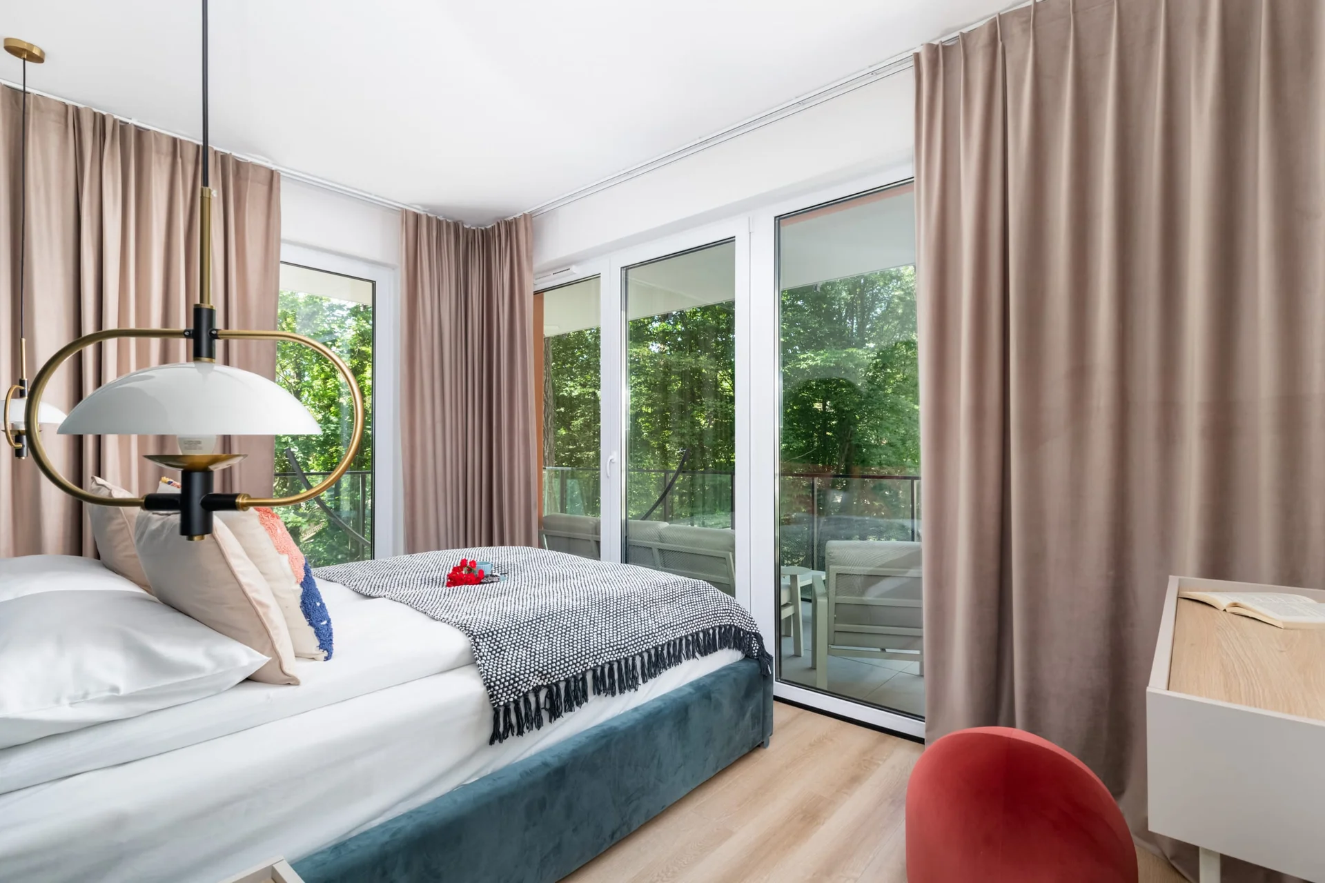 Bright bedroom with a comfortable bed, large windows, and elegant decor.