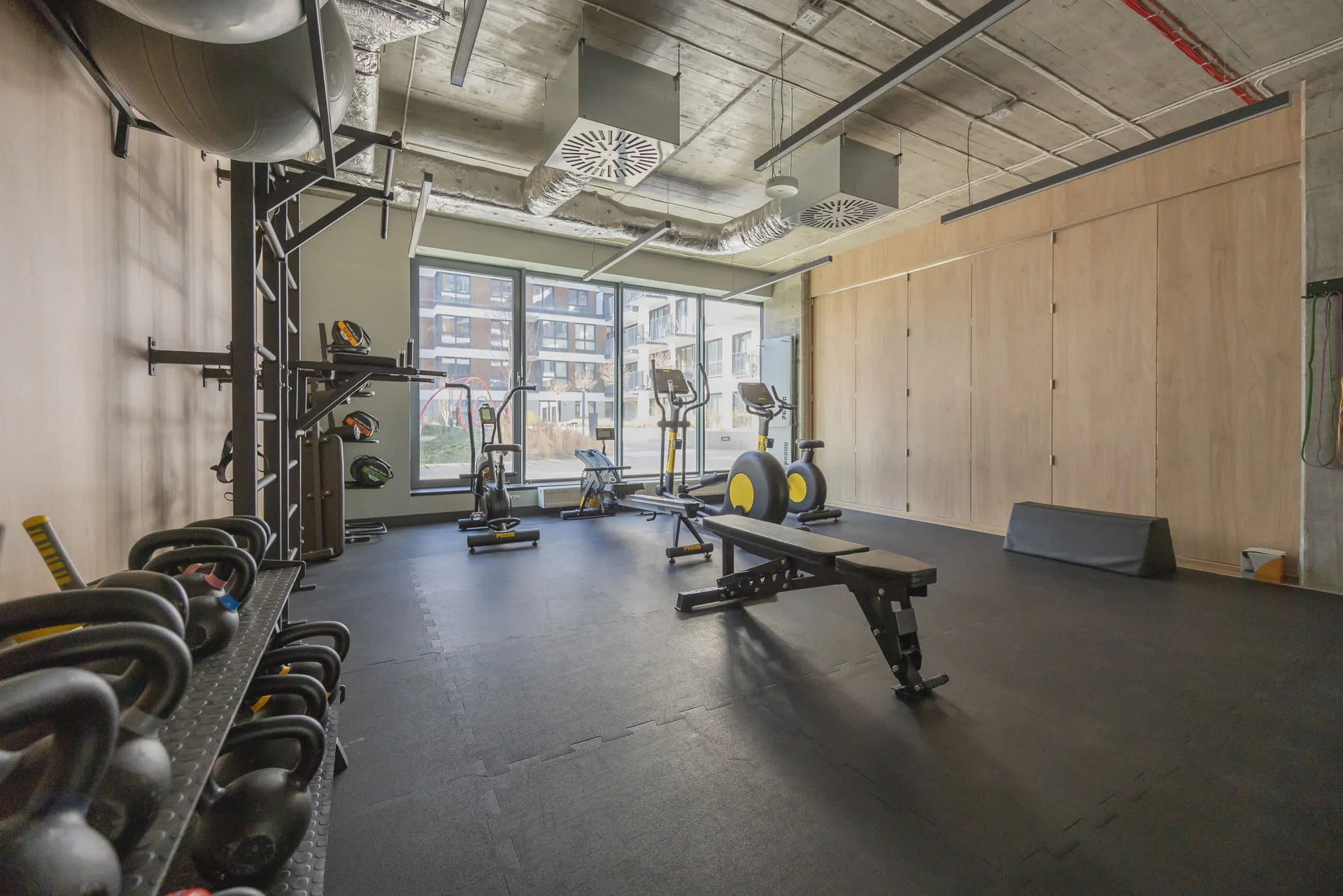 A well-equipped gym with high ceilings, modern exercise machines, and ample space for workouts.