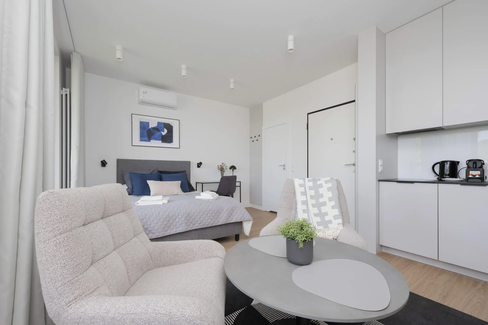 A homey living room with neutral tones, an L-shaped sofa, and a small round table for casual lounging.