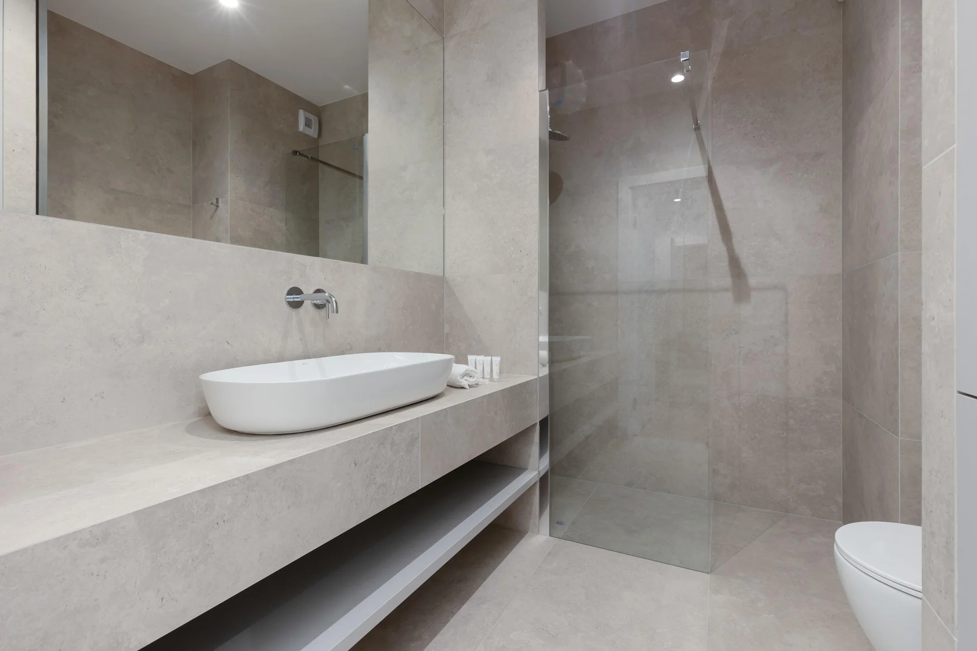 Minimalist, sand-coloured bathroom with walk-in shower.