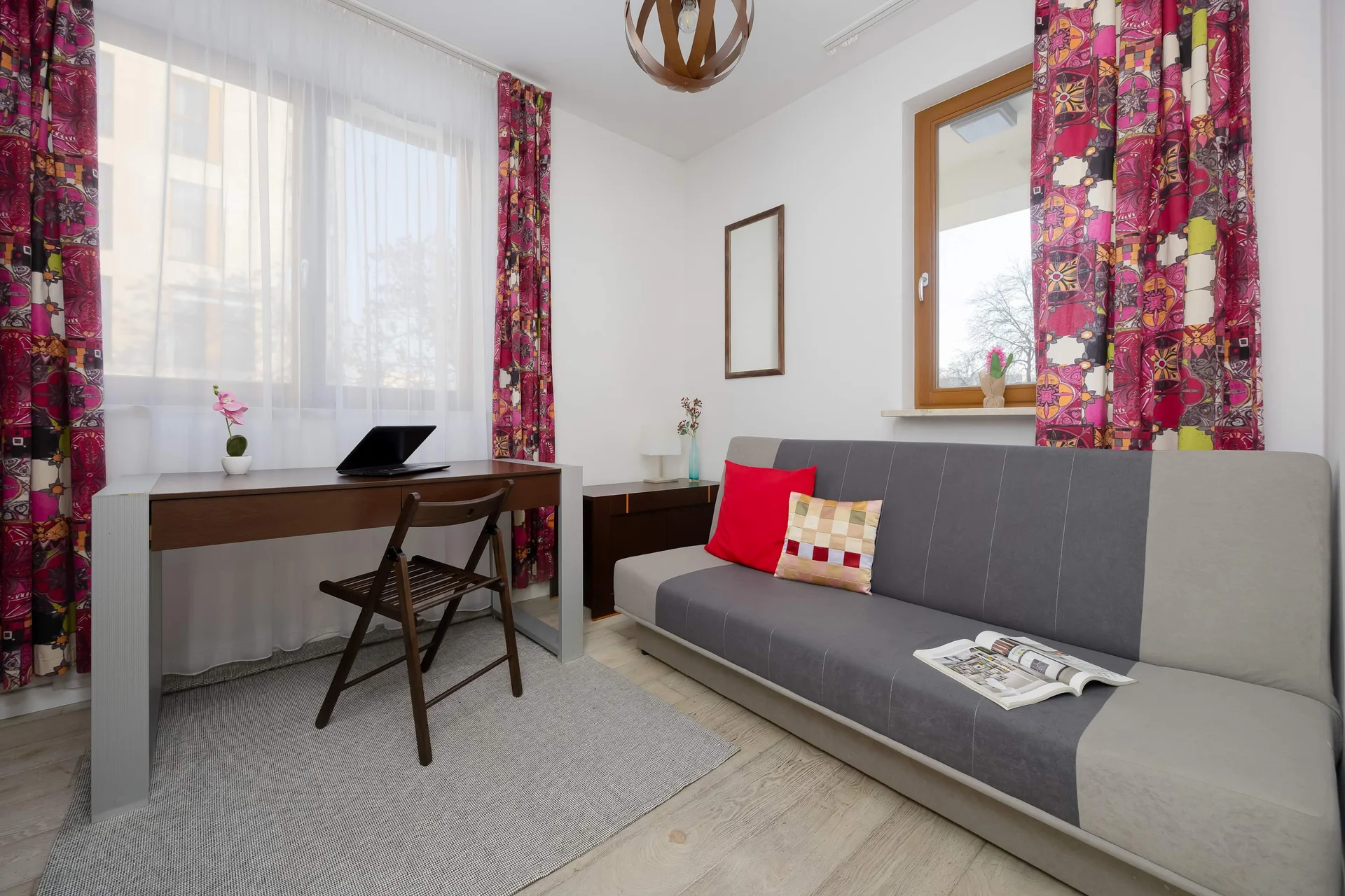 Room with sofa bed and workspace.