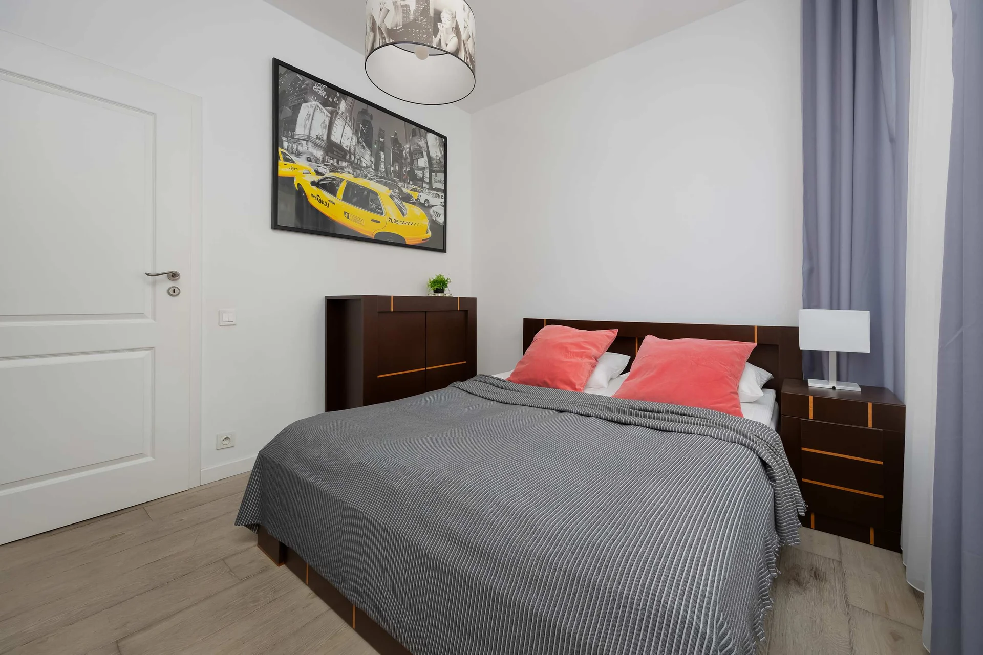 Bedroom with double bed and modern artwork.
