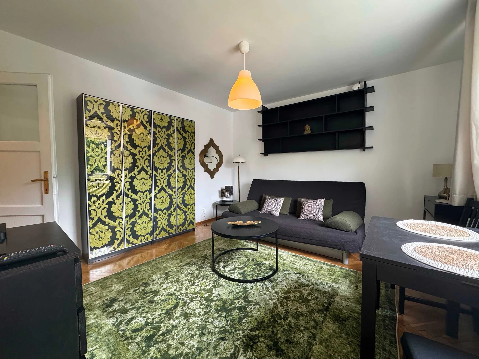 Another angle showcases the seating area with decorative shelving, patterned wall art, and a welcoming lounge layout. The room offers a pleasant space for relaxing after a day out.