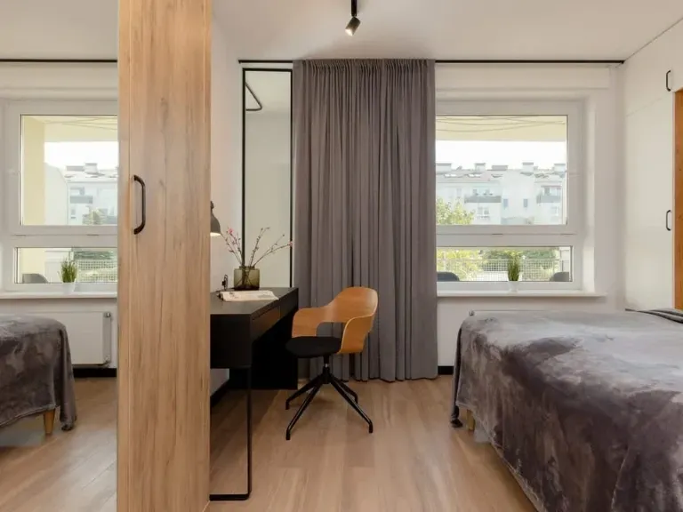 Wnętrze apartamentu, biurko, szafa z lustrem, łóżko