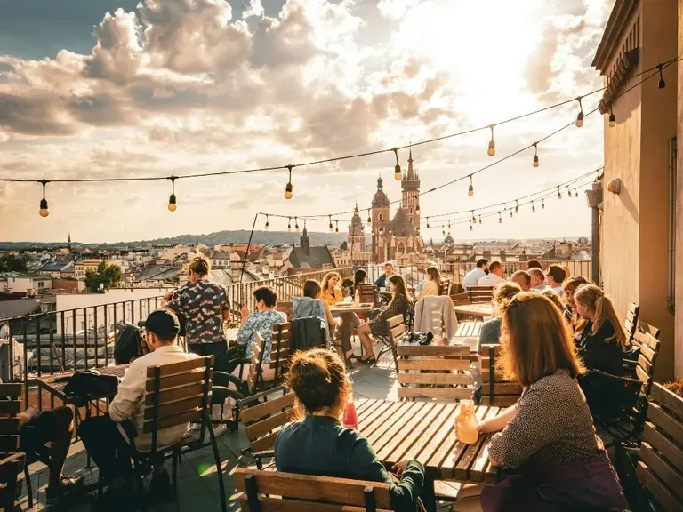 Ludzie na tarasie z widokiem na Stare Miasto w Krakowie