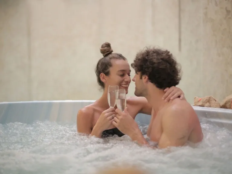 Para zakochanych w jacuzzi z szampanem