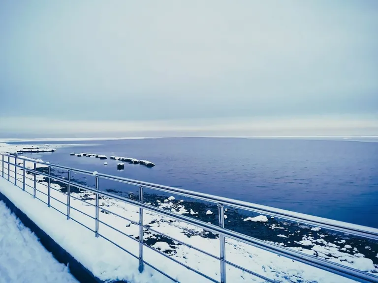 Kołobrzeg zimą, widok na ośnieżoną ścieżkę nad morzem